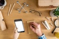 Stylish home office composition of businessman who are using mock up phone screen, office supplies, cacti, phone, notes. Royalty Free Stock Photo