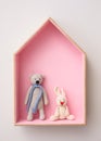 Stylish house shaped shelf with toys on white wall. Baby room interior design