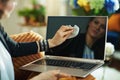 Stylish housewife cleaning laptop screen with cleaning cloth Royalty Free Stock Photo