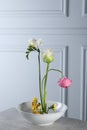 Stylish ikebana as house decor. Beautiful fresh flowers on grey table near white wall Royalty Free Stock Photo