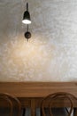 Stylish industrail wall sconce in black metal install on concrete wall with natural wood table top  / copy space / background Royalty Free Stock Photo