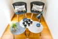 Stylish Interior Decoration of a Cosy Corner of a House with Cast Iron Teapot, Cups, Geometric Tables and Chairs