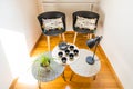 Stylish Interior Decoration of a Cosy Corner of a House with Cast Iron Teapot, Cups, Geometric Tables and Chairs