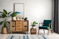 Stylish interior design of living room with wooden retro commode, chair, tropical plant in rattan.