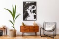 Home decor of stylish vintage room with wooden commode and large poster. Royalty Free Stock Photo