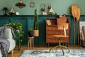 Stylish and vintage interior design of open space with retro furniture, plants and decoration. Royalty Free Stock Photo