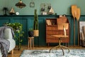 Stylish and vintage interior design of open space with retro furniture, plants and decoration.