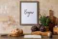 Stylish interior of kitchen space with wooden table, brown mock up photo frame, herbs, vegetables, tea pot, cup. Royalty Free Stock Photo