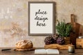 Stylish interior of kitchen space with wooden table, brown mock up photo frame, herbs, vegetables, tea pot, cups and kitchen. Royalty Free Stock Photo