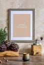 Stylish interior of kitchen space with wooden table, brown mock up photo frame, herbs, vegetables, tea pot, cups and kitchen. Royalty Free Stock Photo