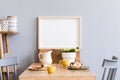 Stylish interior of kitchen space with wooden table with mock up photo frame, design chairs, decoration and furniture. Royalty Free Stock Photo