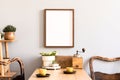 Stylish interior of kitchen space with wooden table with mock up photo frame, design chairs, decoration and furniture. Royalty Free Stock Photo