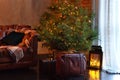 Stylish interior of living room with Christmas fir tree and brown sofa. Beautiful decorated room for Xmas. Loft Interior room with Royalty Free Stock Photo
