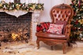 Stylish interior of room with Christmas fir tree and brown armchair. Beautiful cozy decorated living room for Christmas with firep Royalty Free Stock Photo