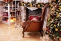 Stylish interior of room with Christmas fir tree and brown armchair. Beautiful cozy decorated living room for Christmas with firep Royalty Free Stock Photo