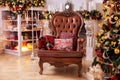 Stylish interior of room with Christmas fir tree and brown armchair. Royalty Free Stock Photo