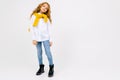 Stylish joyful caucasian teenager in a white shirt and blue jeans in full growth on a white background with copy space