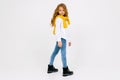 Stylish joyful caucasian teenager in a white shirt and blue jeans in full growth on a white background with copy space