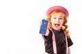 stylish kid in pink hat and suspenders showing smartphone with facebook page