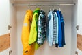 Stylish kids clothes in white wardrobe closet. Kids clothing on hangers in the closet. Storage organization Royalty Free Stock Photo