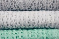 Stylish knitted pastel colored sweaters folded in stack. Winter and spring season knitwear clothing. Close up, copy