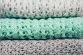 Stylish knitted pastel colored sweaters folded in stack. Winter and spring season knitwear clothing. Close up, copy