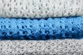 Stylish knitted pastel colored sweaters and one in trendy blue color folded in stack. Winter and spring season knitwear