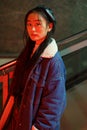 Stylish korean girl in trendy outfit and leather beret. Young asian female at neon city light Royalty Free Stock Photo