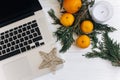 Stylish laptop and christmas oranges and golden star and candle Royalty Free Stock Photo