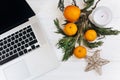 Stylish laptop and christmas oranges and golden star and candle Royalty Free Stock Photo