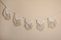 Stylish large macrame hanging on beige wall