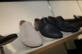 Stylish leather, lacquered mens shoes on the shelf in the store