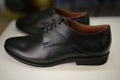 Stylish leather, lacquered mens shoes on the shelf in the store