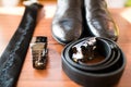 Stylish leather men`s shoes in focus, watch, tie, belt for groom. Wedding accessories on rustic brown wooden background. tradition Royalty Free Stock Photo