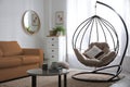 Stylish leather sofa and swing chair in living room interior Royalty Free Stock Photo