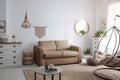 Stylish leather sofa and swing chair in living room interior Royalty Free Stock Photo