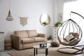 Stylish leather sofa and swing chair in living room interior Royalty Free Stock Photo