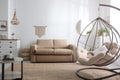 Stylish leather sofa and swing chair in living room interior Royalty Free Stock Photo