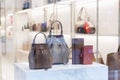 Stylish leather women`s bags in a shop window. Expensive elegant accessories Royalty Free Stock Photo