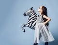 Stylish little asian girl kid in high fashion clothes and sunglasses posing in profile with zebra metallic balloon on menthol blue Royalty Free Stock Photo