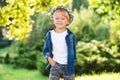 Stylish little boy posing at summer park. Fashion, lifestyle and summer concept. Happy child walking in sunny day Royalty Free Stock Photo