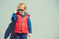 Stylish little boy in sunglasses. Children`s fashion. Funny kid walking city street, autumn fashion. Fashionable boy posing in Royalty Free Stock Photo