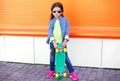 Stylish little girl child with skateboard wearing a sunglasses and checkered shirt Royalty Free Stock Photo