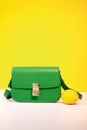 stylish little green purse or handbag on yellow background with a lemon nearby. Product composition photography. bag and Royalty Free Stock Photo