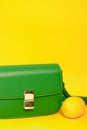 stylish little green purse or handbag on yellow background with a lemon nearby. Product composition photography. bag and Royalty Free Stock Photo