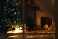 Stylish living room interior with decorated Christmas tree and fireplace at night Royalty Free Stock Photo