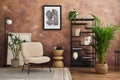 Stylish living room interior design with mock up poster frame frotte armchair, black metal shelf, side table, plants. Royalty Free Stock Photo