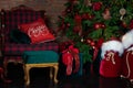 Stylish loft interior of room with Christmas fir tree and checkered armchair. Red sack santa claus with gifts near big Christmas f Royalty Free Stock Photo