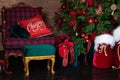 Stylish loft interior of room with Christmas fir tree and checkered armchair. Red sack santa claus with gifts near big Christmas f Royalty Free Stock Photo