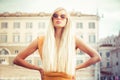 Stylish long blond hair young woman with sunglasses in the city Royalty Free Stock Photo